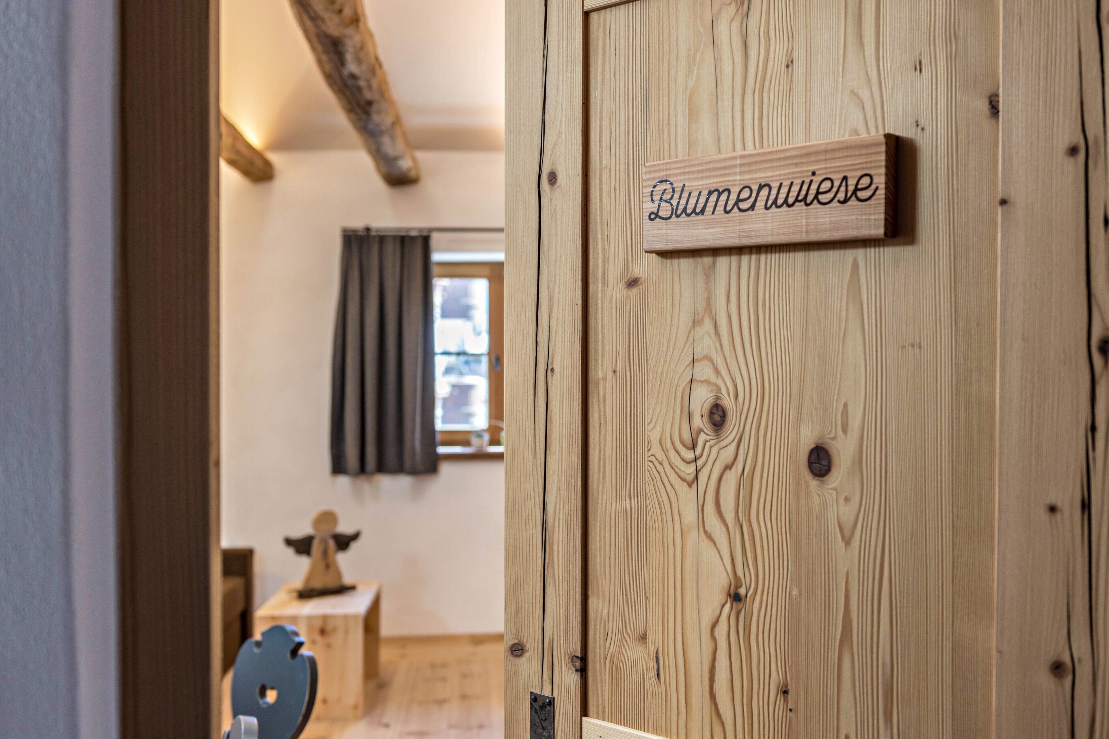A wooden door with a sign reading 'Blumenwiese.'