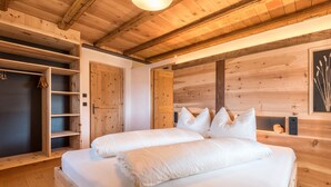 Une chambre à coucher en bois avec deux lits, des étagères intégrées et un plafond en bois.