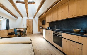 A compact kitchen with wooden cabinets, a built-in oven, and a black countertop.