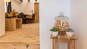 Un pavimento in legno, un tavolino con due piante in vaso e un barattolo con coperchio.