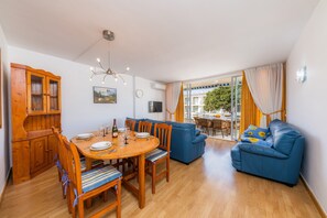 A dining area with a wooden table, chairs, and a blue sofa.