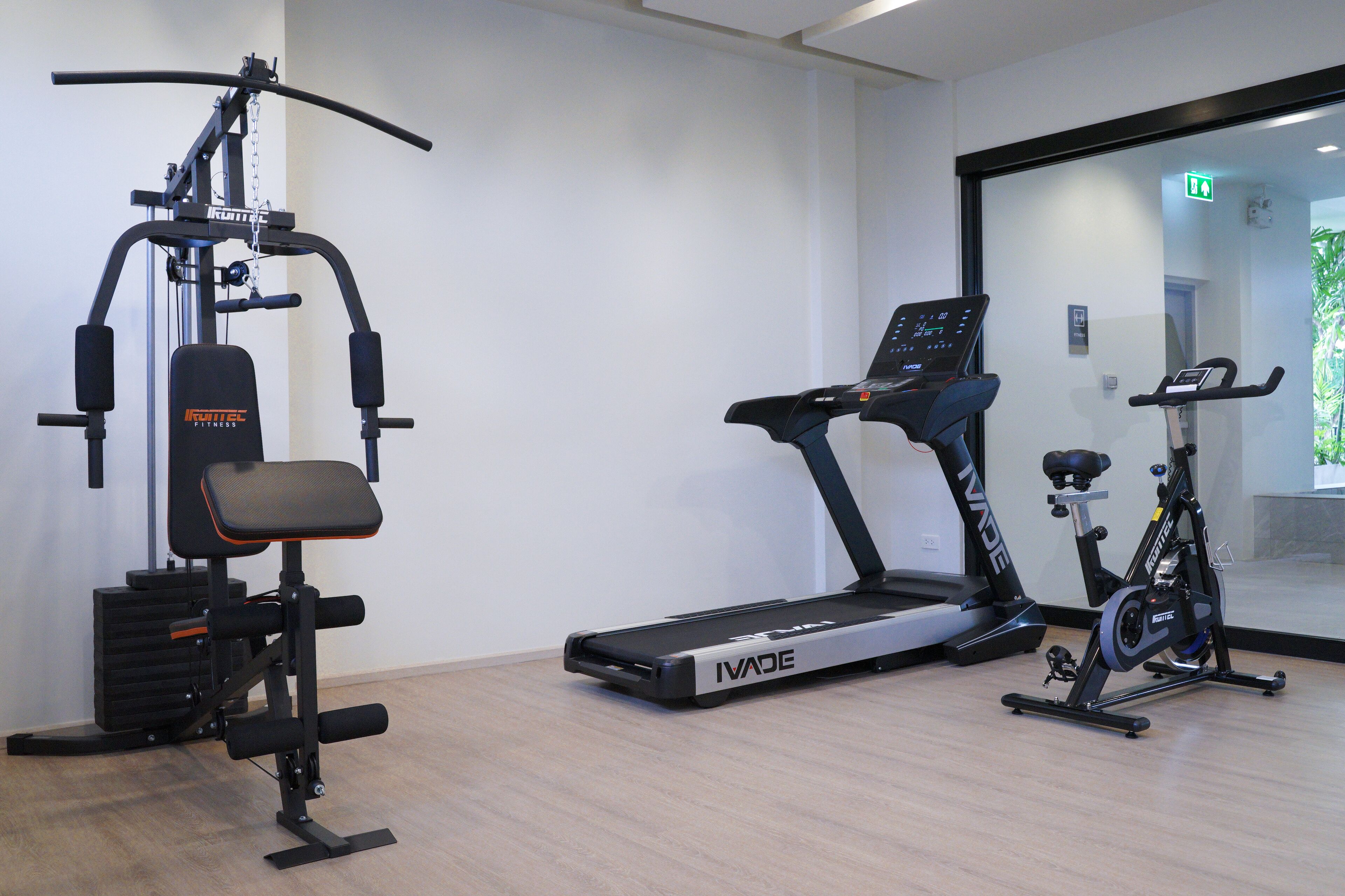 A gym with an I-VaDE elliptical, a treadmill, and a stationary bike.