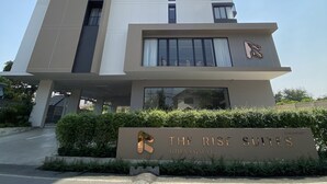 A modern hotel building with a prominent sign reading "THE RISE SUITES CHANGMAI". - The Rise Suites Hotel Chiang Mai  (Chiang Mai)