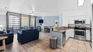 A modern apartment with a living room, kitchen, and balcony. - 1322 Pool & Beach views, w/2 parking passes, lagoon-style pool & indoor pool (Panama City Beach)