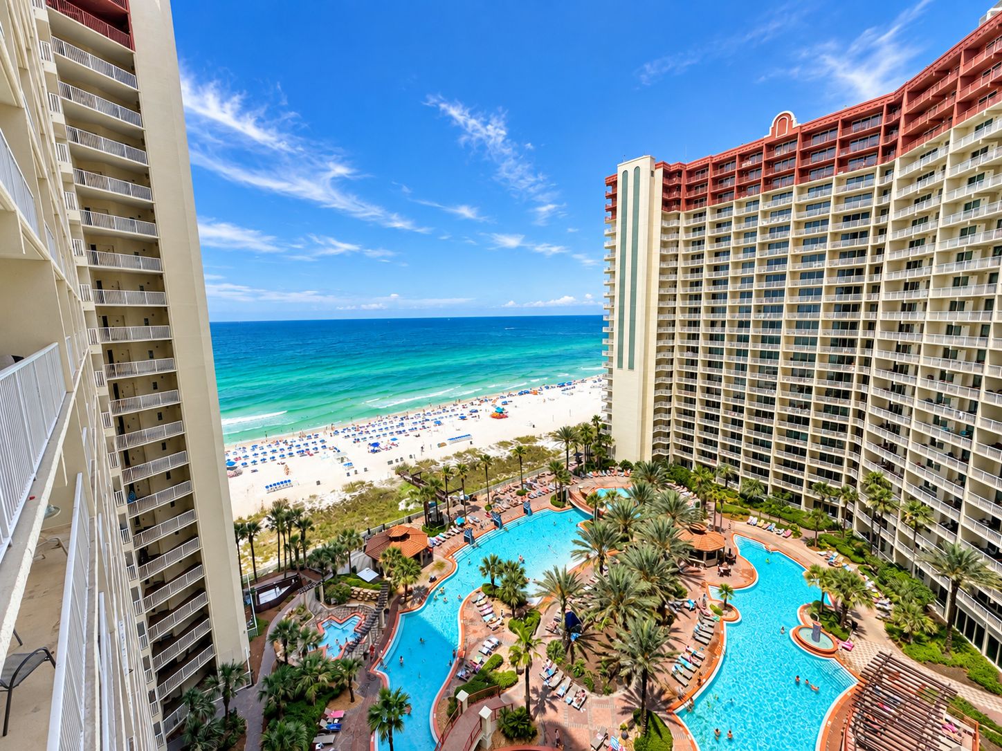 Un resort con una amplia zona de piscina, acceso a la playa y edificios de gran altura.