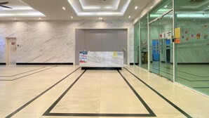 A spacious lobby with a marble floor, a reception desk, and a ceiling fan. - OYO 90192 Mansion One Suites (George Town)