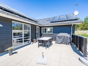 A modern house with a patio, solar panels, and a satellite dish. - 5 Star Holiday Home in Blavand (Blavand)