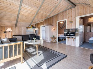 A cozy cabin interior with a living area, kitchenette, and a sleeping space. - 4 Star Holiday Home in Hvide Sande (Hvide Sande)