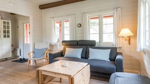 A cozy living room with a sofa, a wooden coffee table, and a lamp.