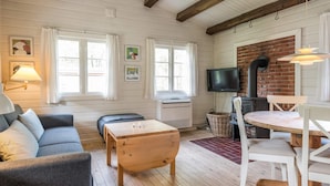 A cozy living room with a sofa, wooden coffee table, and a dining area with a table and chairs.