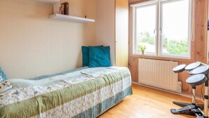 Ein Schlafzimmer mit Bett, Fenster, Heizkörper und Laufband.