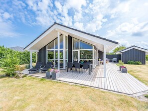A modern house with a large deck, outdoor seating, and a covered patio area. - Holiday Home in Tarm (Tarm)