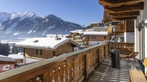 A wooden balcony with a view of snow-covered mountains. - Inviting Chalet in Neukirchen near Wildkogel Ski Arena (Neukirchen am Grossvenediger)