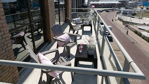 A balcony with seating, a table, and a potted plant. - Apartment in Den Haag With sea Beach (The Hague)