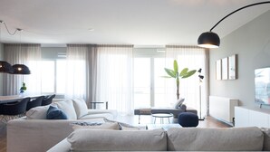Un salon moderne avec un canapé, une table à manger et une plante.