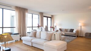 Una sala moderna con un sofá seccional, una mesita auxiliar y una lámpara de pie.