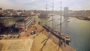 A waterfront area with a dock, a flag, and a marina. - Ground Floor Apartment near Scheveningen (The Hague)