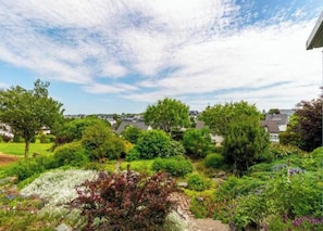 Un quartier résidentiel avec des maisons, une végétation luxuriante et un ciel dégagé.