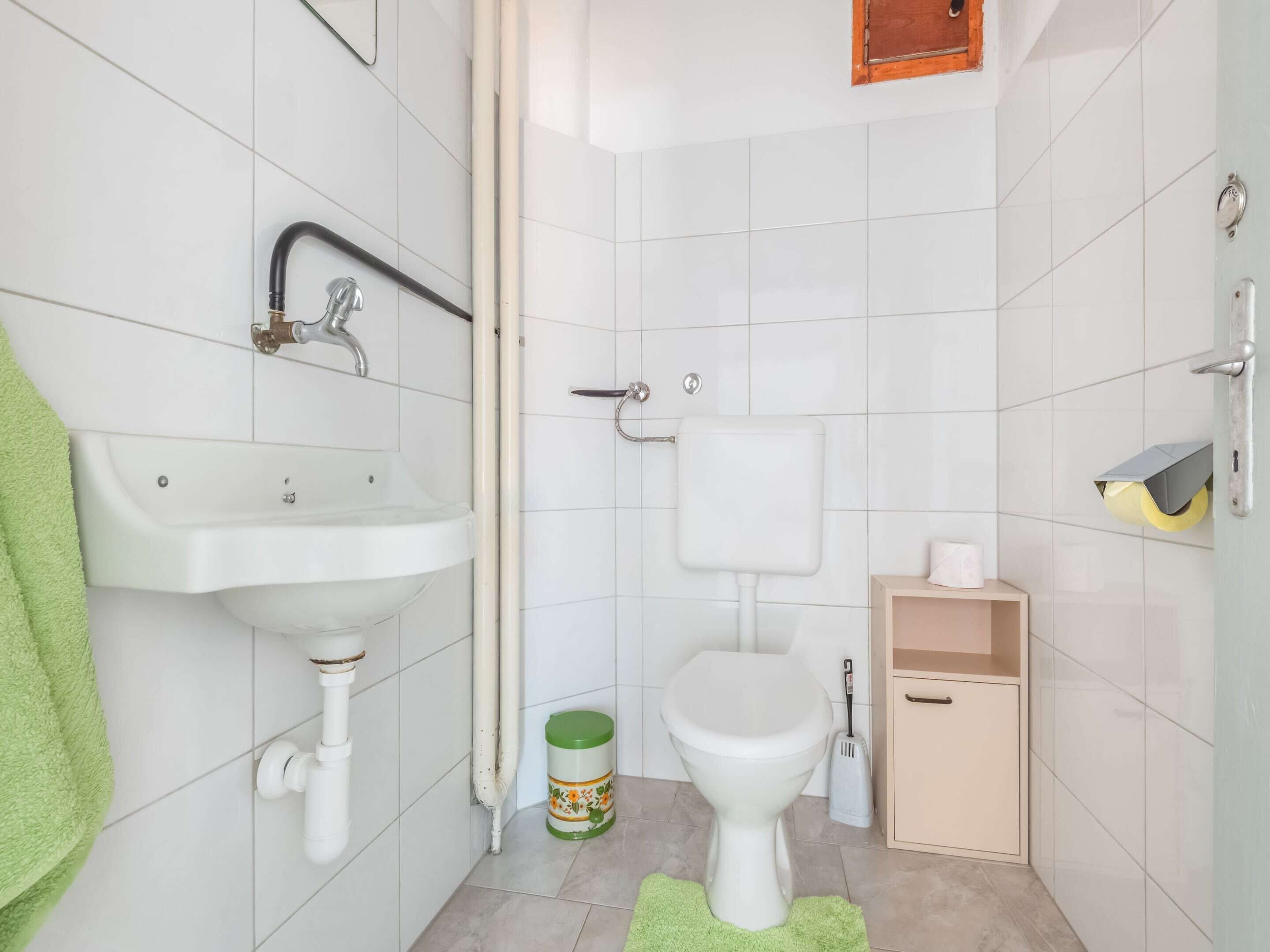 Une salle de bain équipée d’un lavabo, de toilettes et d’un meuble de rangement.
