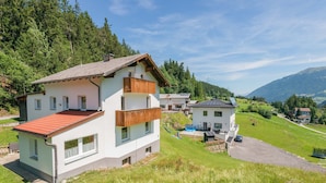 A two-story house with a red-tiled roof, a balcony, and a small swimming pool. - Chalet in Tyrol Near Ski Resort (Fliess)