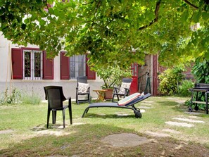 A garden with outdoor seating, including a lounge chair and two chairs, a small table, and a potted plant. - Studio in Astigiana Hills With Wine & Views (Moncucco Torinese)