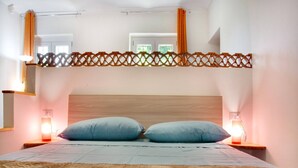 A bedroom with a bunk bed, two bedside lamps, a wooden headboard, and a window with curtains. - Charming Vacation House in Countryside (Moncucco Torinese)