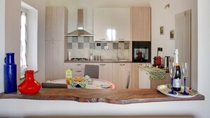 A modern kitchen with light wood cabinets, a stainless steel range hood, and a built-in oven. - Casa Vacanze a Moncucco Torinese (Moncucco Torinese)