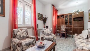 Un salón con sofás de estampado floral, un aparador de madera y una mesa de comedor.