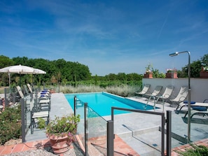A rooftop pool with clear blue water, surrounded by lounge chairs and umbrellas. - Plush Holiday Home in Cortona with Hot Tub (Cortona)