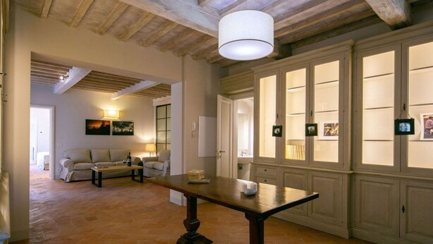 A spacious room with a wooden table, a sofa, and a large window with multiple panes. - Plush Holiday Home in Cortona with Hot Tub (Cortona)
