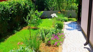 A garden with a paved walkway, various plants, and flowers. - Apartment in Valbandon With Terrace (Fazana)