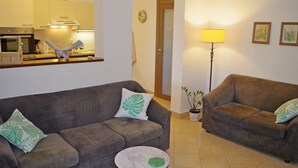 A living room with two sofas, a small round table, a lamp, and a potted plant. - Apartment in Valbandon With Terrace (Fazana)