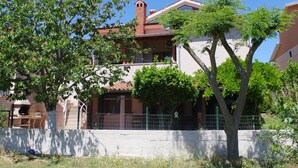 A two-story building with a red-tiled roof, a small tower-like structure, and a balcony. - Apartment in Valbandon With Terrace (Fazana)