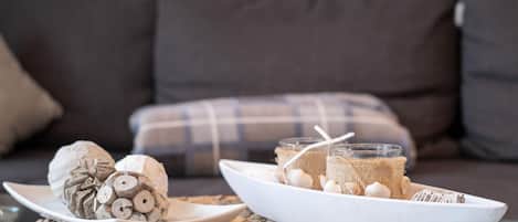 A dining setup with a woven placemat, a plate with rolled items, and a glass with a burlap-wrapped item and a straw.