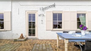 A white brick building with a sign reading "t Gernerf" above the door. - Holiday Home in Stavele With Terrace (Alveringem)