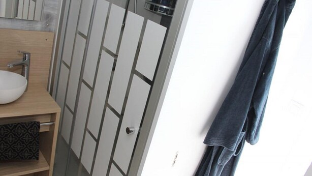 A bathroom with a white sink, a mirror, and a towel rack. - Chalet in Friesland Near Alde Feanen Park (De Veenhoop)