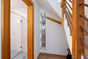 Eine Holztreppe mit Metallgeländer und einem an der Wand befestigten Metallregal.