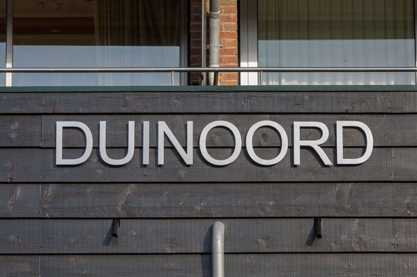 Une enseigne en bois portant l’inscription « DUINOORD ».