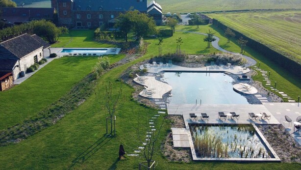 An aerial view of a property with a large swimming pool, outdoor seating area, and a building with multiple windows. - Nice Cottage in a Castle-farm in Ohey With Swimming Pond (Ohey)