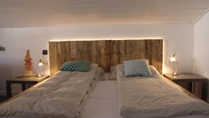 Ein Doppelbett mit Holz-Kopfteil, zwei Nachttische mit Lampen und eine kleine Statue auf einem Tisch.
