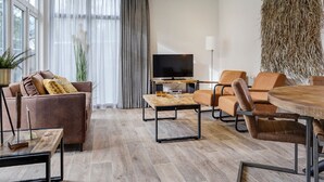 A modern living room with a sofa, armchairs, a coffee table, and a TV. - Chalet by Forest Edge With Modern Design (Markelo)