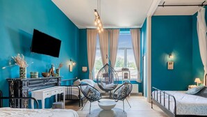 A modern bedroom with teal walls, a hanging chair, a bed, a desk, and a TV mounted on the wall. - Castle With Wellness and Cinema (Gesves)