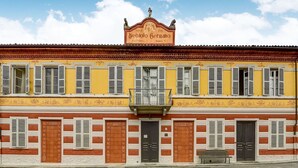 Een geel gebouw met een bord waarop staat: Vini Nebiolo Custo Fiorino.