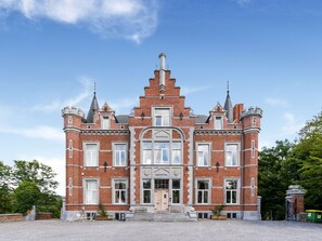 A large, historic building with a symmetrical facade, multiple windows, and a central entrance. - Renovated Appartment in Castle (Gesves)