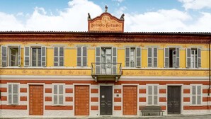 A yellow building with a sign reading "Vine Nebiolo Custo Fiorino." - Apartment in Portacomaro With Garden (Portacomaro)