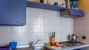 Eine Küche mit Spüle, Herd und blauen Schränken.