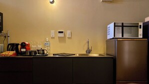 A kitchen with a stainless steel refrigerator, a microwave, a coffee maker, and a water dispenser. - Campton Higashiyama Roku (Kyoto)