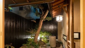 A traditional Japanese garden with a wooden structure, a stone lantern, and a small pond. - Campton Higashiyama Roku (Kyoto)