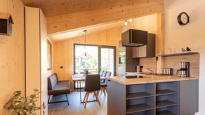 Eine moderne Küche mit Kochinsel, Holzschränken und integriertem Backofen.