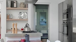 A modern kitchen with a central island, stainless steel appliances, and a dining area with white chairs. - Family Home Near Sea & Dunes (Noordwijk)